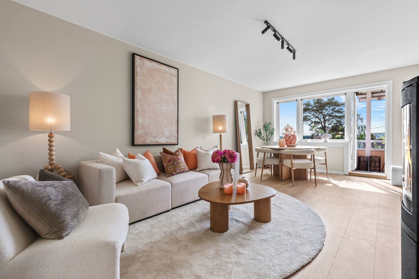 Leiligheten har en innbydende stue med plass til både spisebord og sofagruppe. Overflatene er holdt i lyse farger, med slette vegger og laminatgulv. Galleribilde