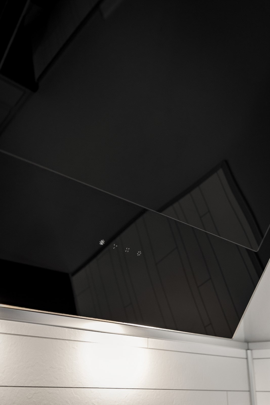 Moderne, vegghengt ventilator over platetoppen. Galleribilde