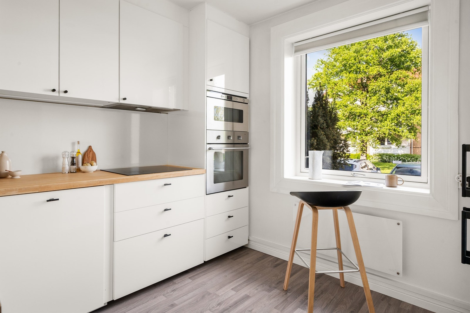 Benkeplate i heltre gir en varm kontrast til den hvite innredningen. Oppvaskmaskin er integrert. Galleribilde