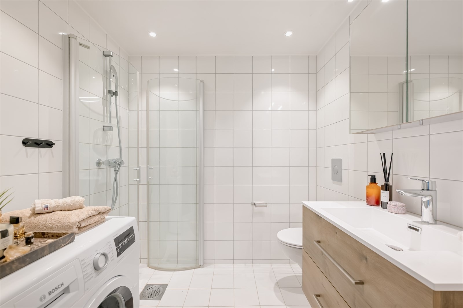 Flislagt bad med gulvvarme, integrert himlingsbelysning og dusjhjørne. Badet er oppført i 2006 og i 2025 ble baderomsinnredningen fornyet. Galleribilde