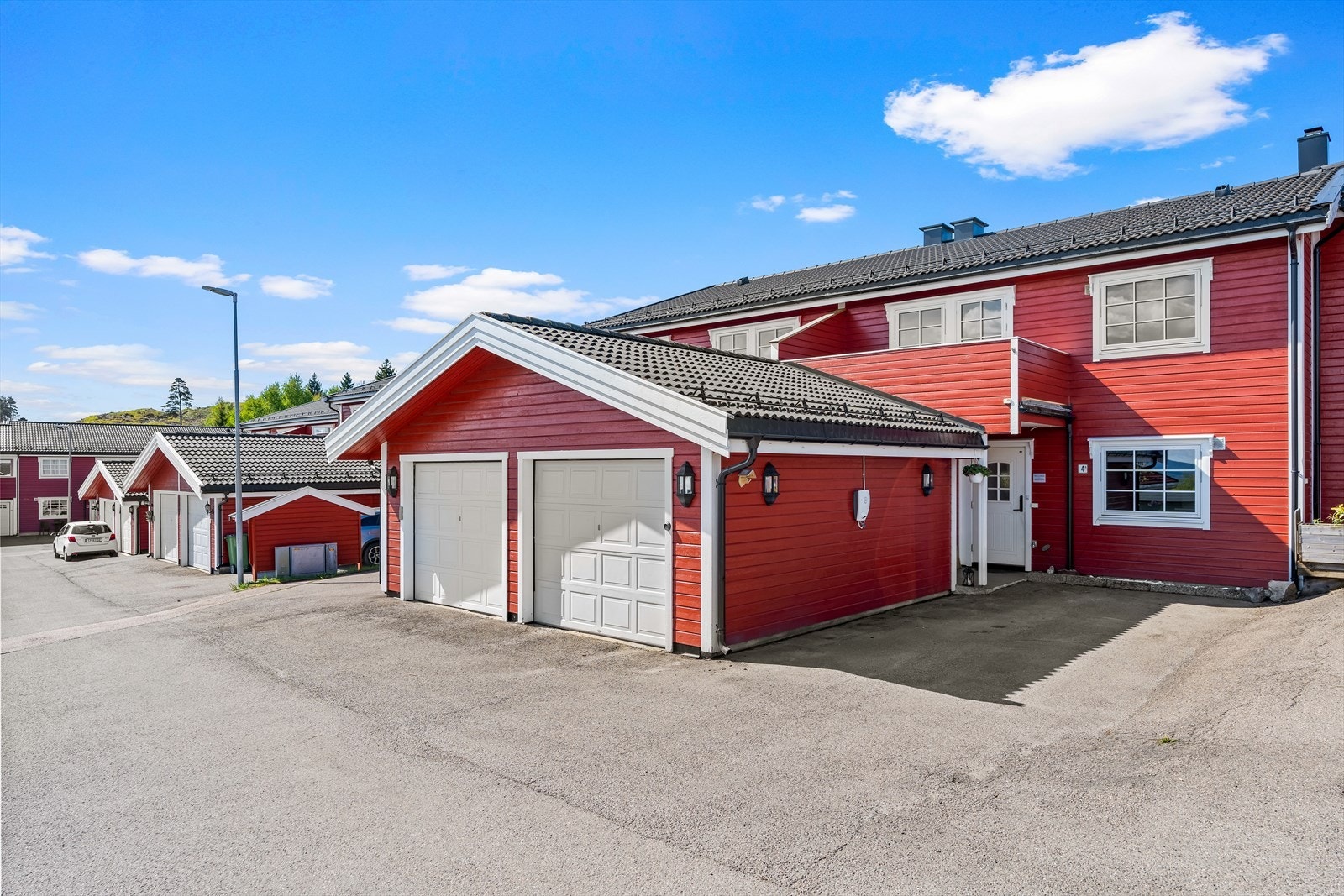 Det disponeres en garasje på BRA-e 17 m². Det er montert elbillader på veggen utenfor garasjen. Galleribilde