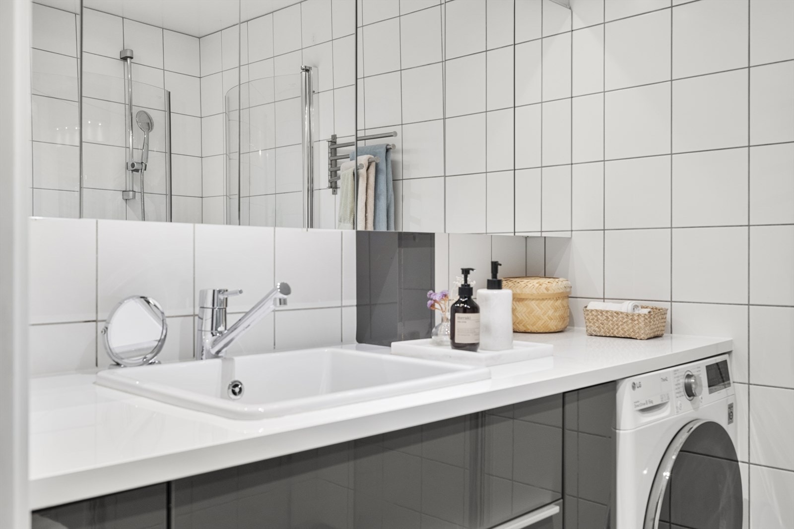 Badet er utstyrt med vegghengt toalett, servantinnredning med servant, ettgreps blandebatteri, speilskap, dusjarmatur og dusjdører i glass. Galleribilde