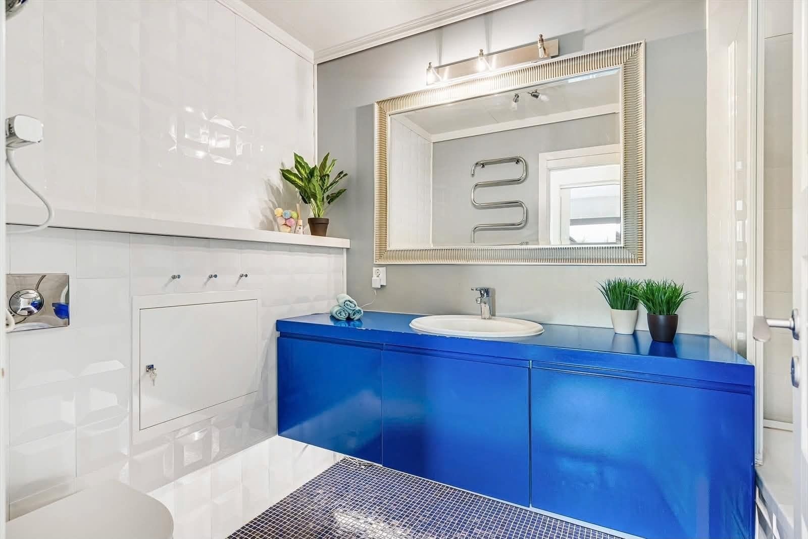 Badet. Benkeplate er noe preget av fukt rundt vasken. Galleribilde