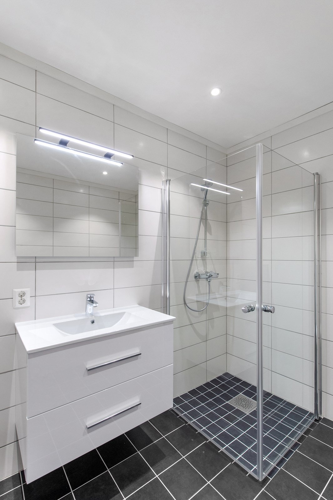 Badet er utstyrt med baderomsinnredning med speil og har opplegg for vaskemaskin. Galleribilde