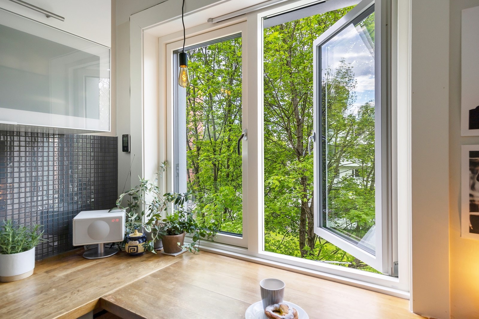 Hyggelig sitteplass ved kjøkkenvinduet - perfekt for kaffe i morgensolen omkranset av trær og vegetasjon. Galleribilde