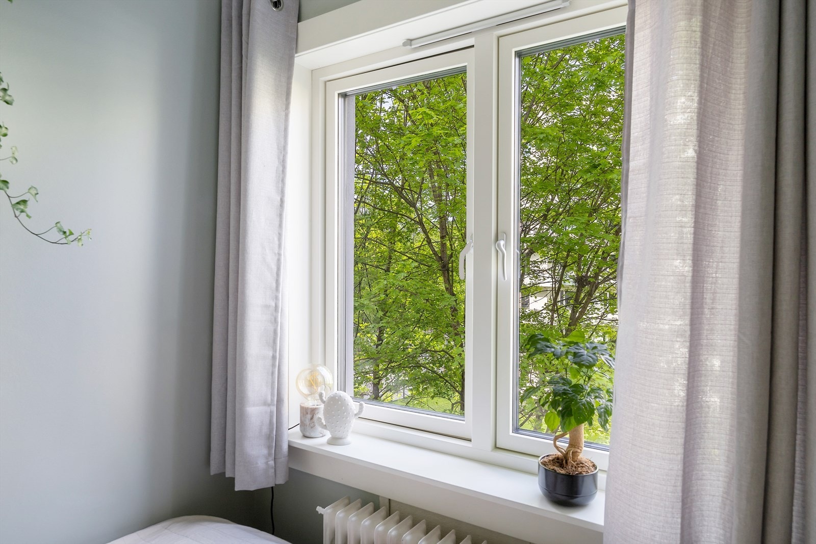 Rommet har plass til seng og oppbevaringsløsninger, og nyter godt av grønt utsyn og morgensol. Galleribilde