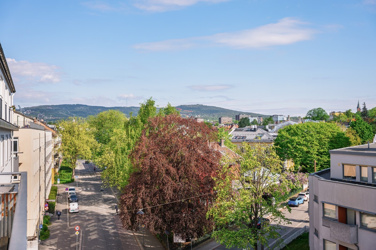 Fra toppetasjen er det en åpen utsikt over nabolaget, med et glimt av Holmenkollen i det fjerne. Galleribilde