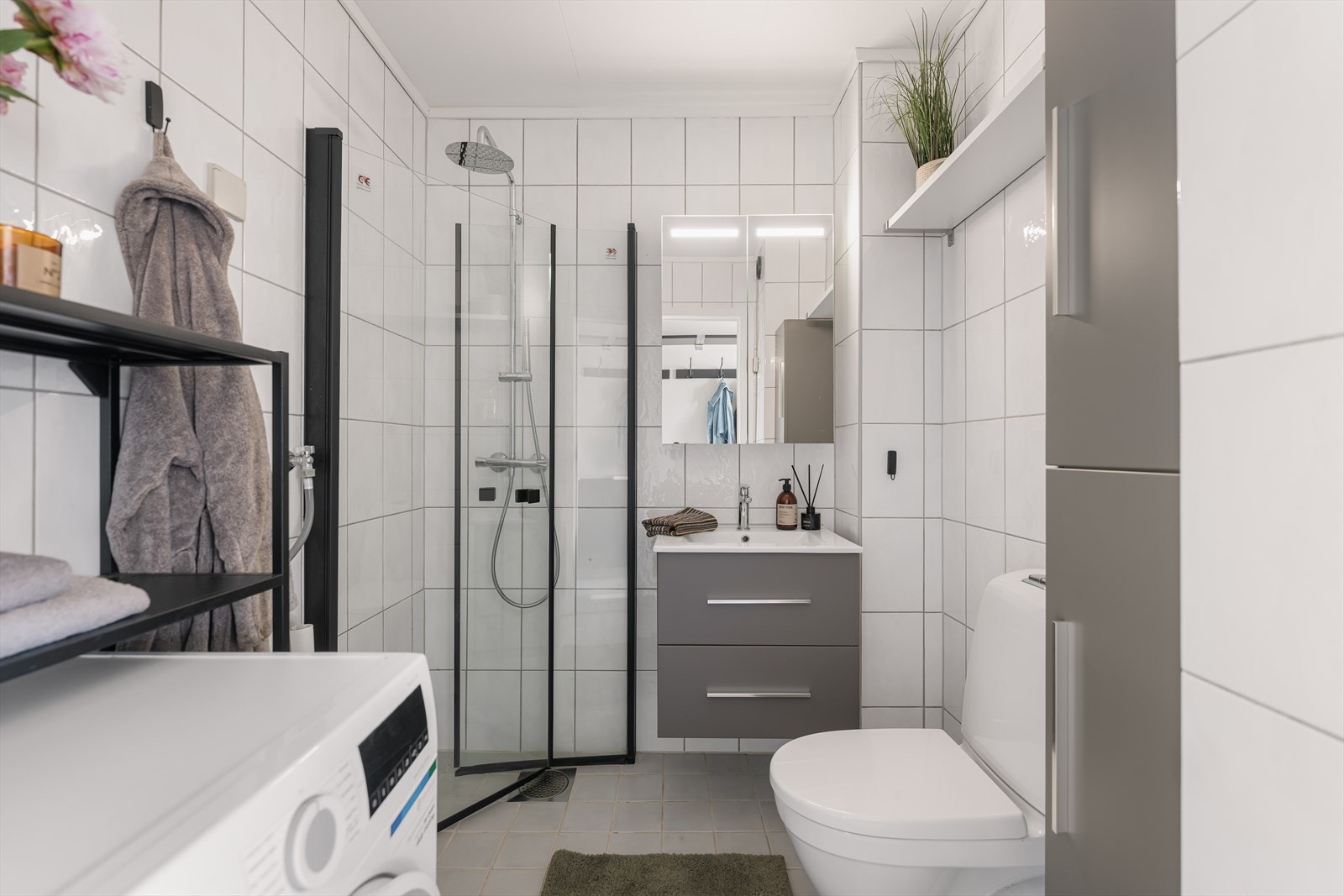 Badet er funksjonelt innredet med plass til både vaskemaskin og oppbevaring. Galleribilde