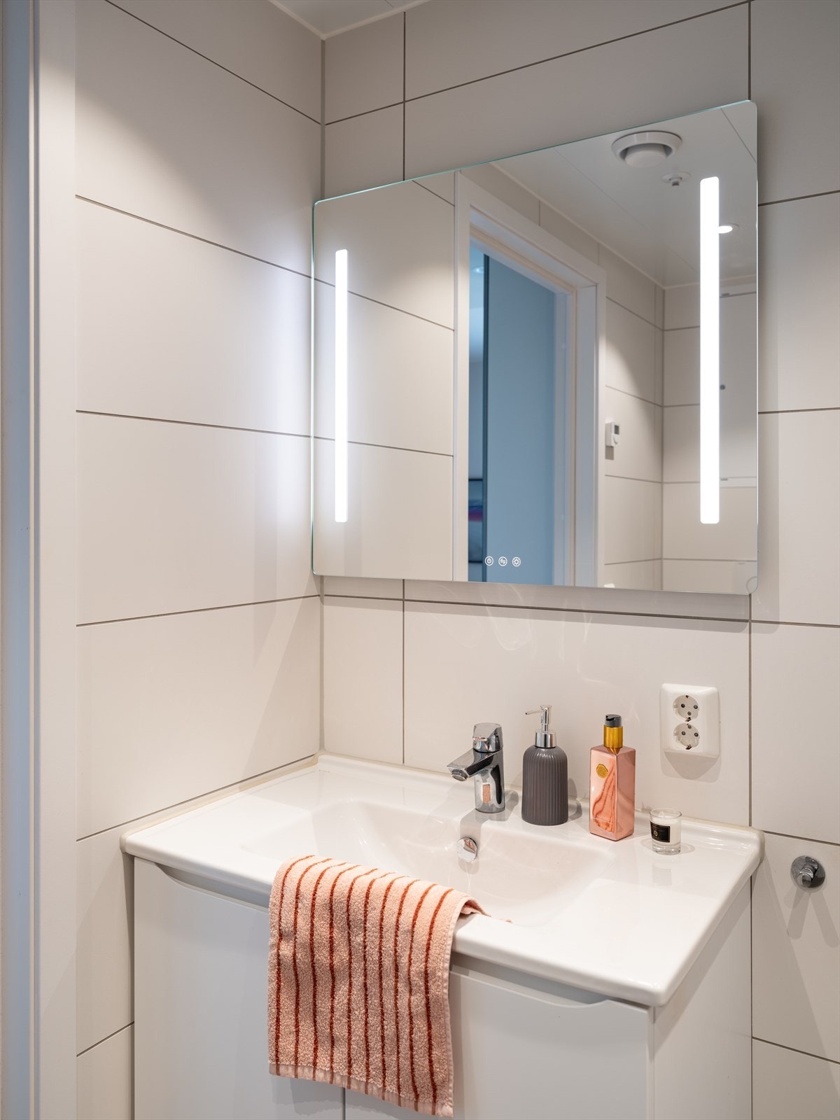Badet er utstyrt med servant, dusjhjørne med innfellbare dusjdører, vegghengt toalett og opplegg for vaskemaskin. Galleribilde