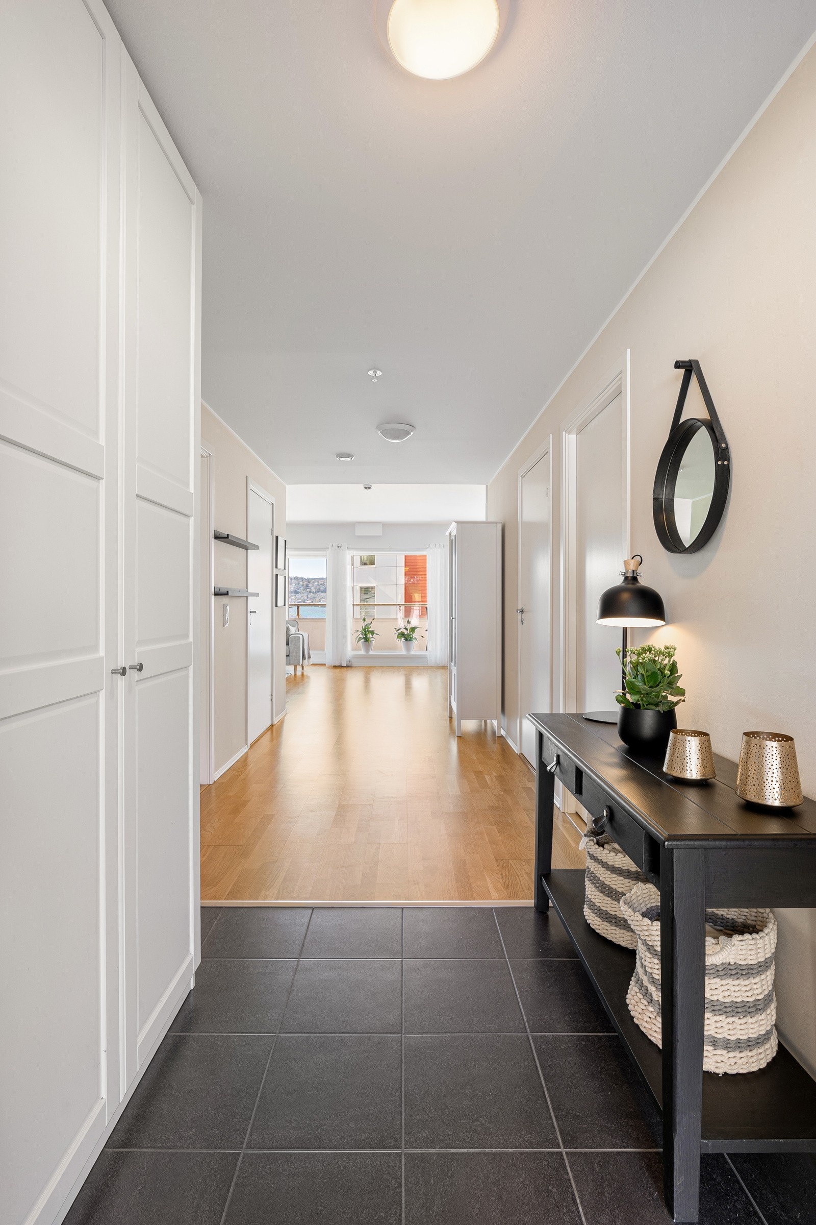Innbydende og romslig entré med fliser på gulv, gulvvarme og garderobe