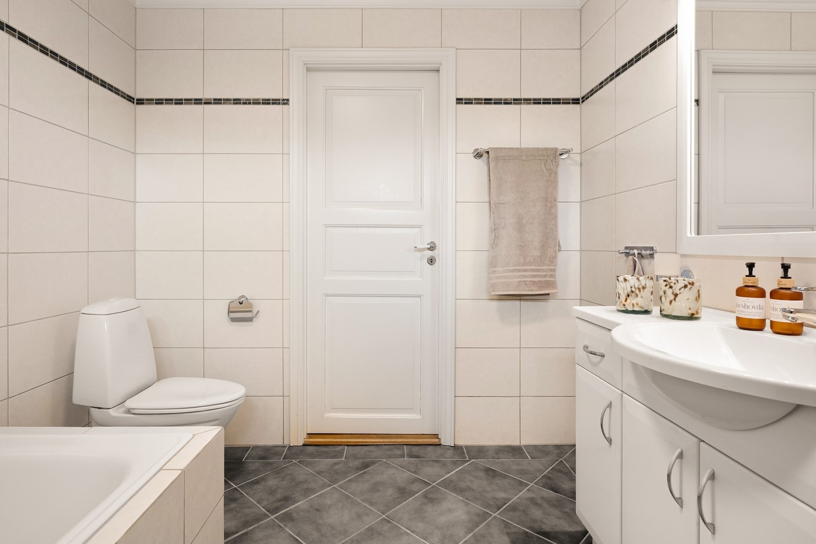 Badet er utstyrt med badekar, toalett og servant Galleribilde