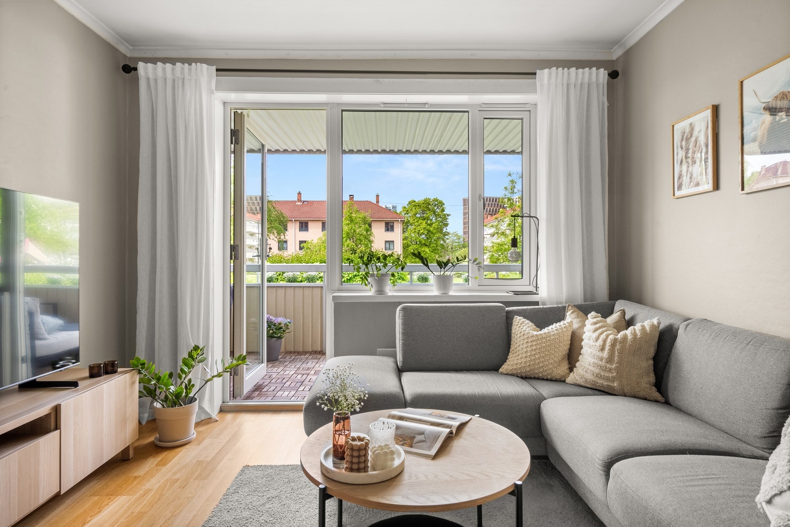 Store vindusflater og balkongdør fra 2018 slipper inn dagslys i stuen. Galleribilde