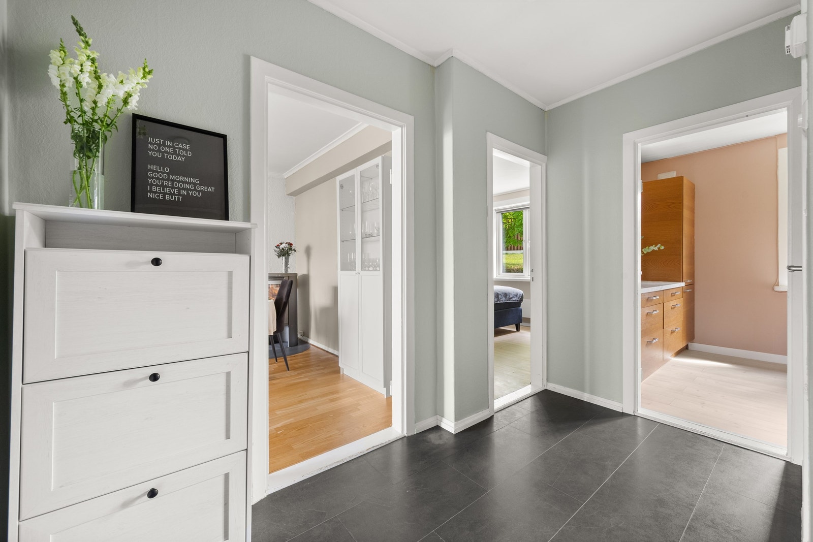 Romslig entré med mørke laminatfliser på gulv og lyse veggflater som gir et lyst og ryddig førsteinntrykk. Det er gode oppbevaringsmuligheter med innvendig kott i tilknytning til entréen. Galleribilde
