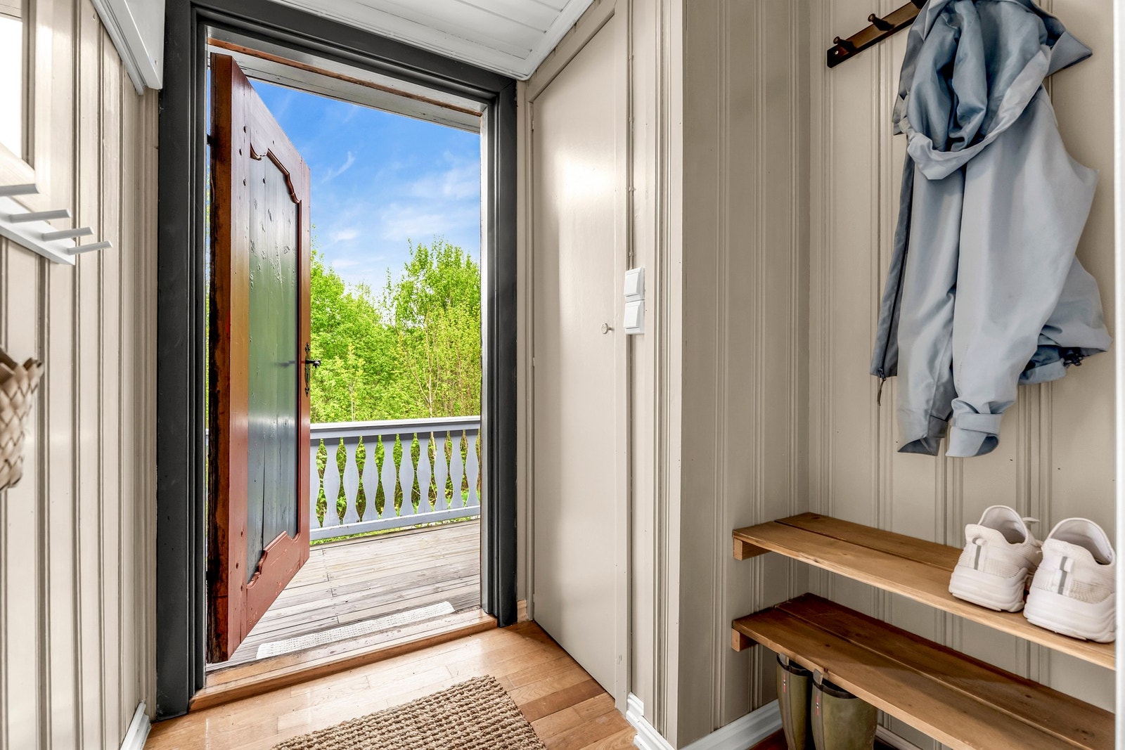 Entré med utgang til balkong og utsikt mot grøntområder. Galleribilde