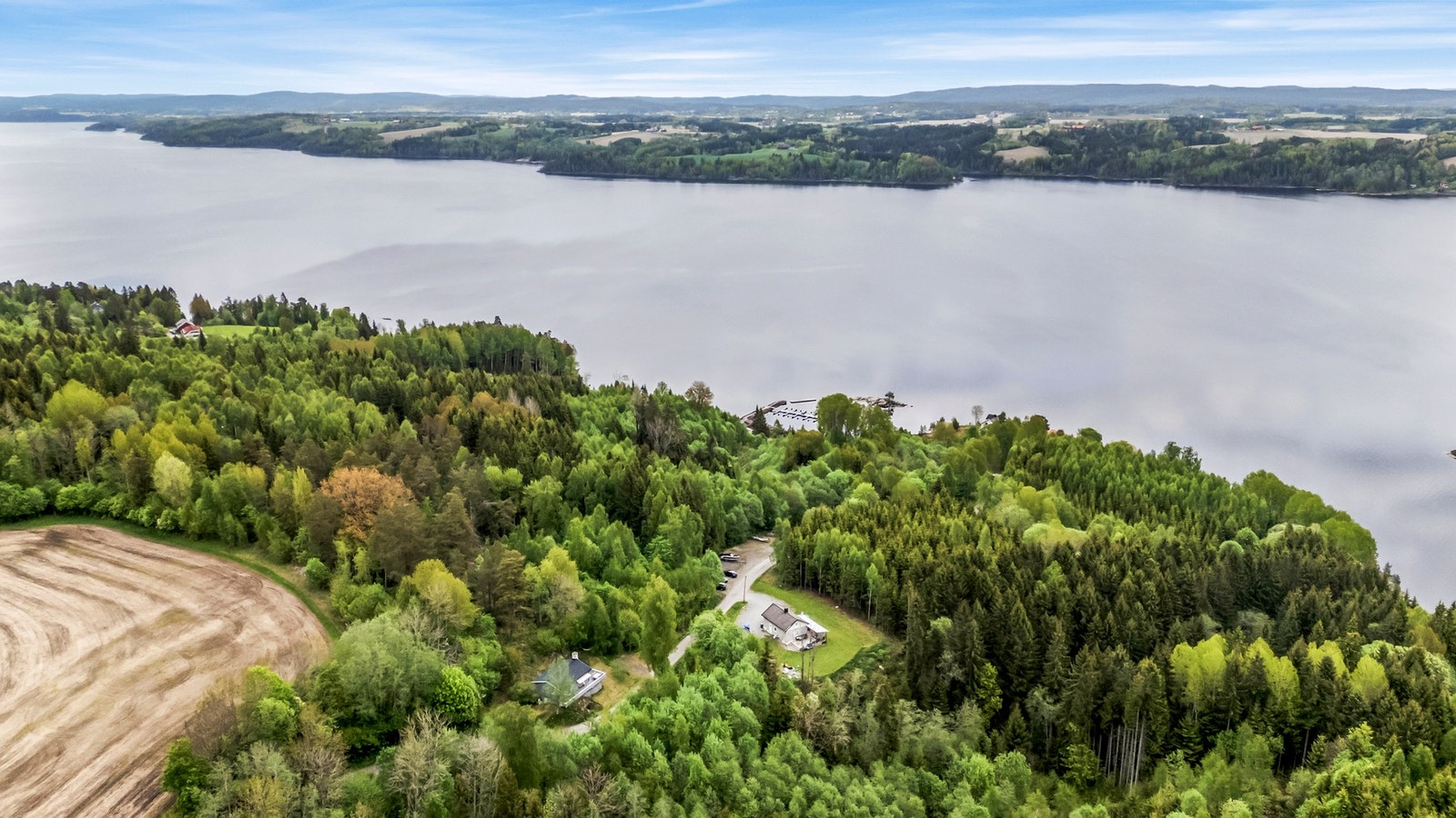 Boligen ligger i et naturskjønt område med utsikt over vannet og omgitt av frodig skog. Galleribilde