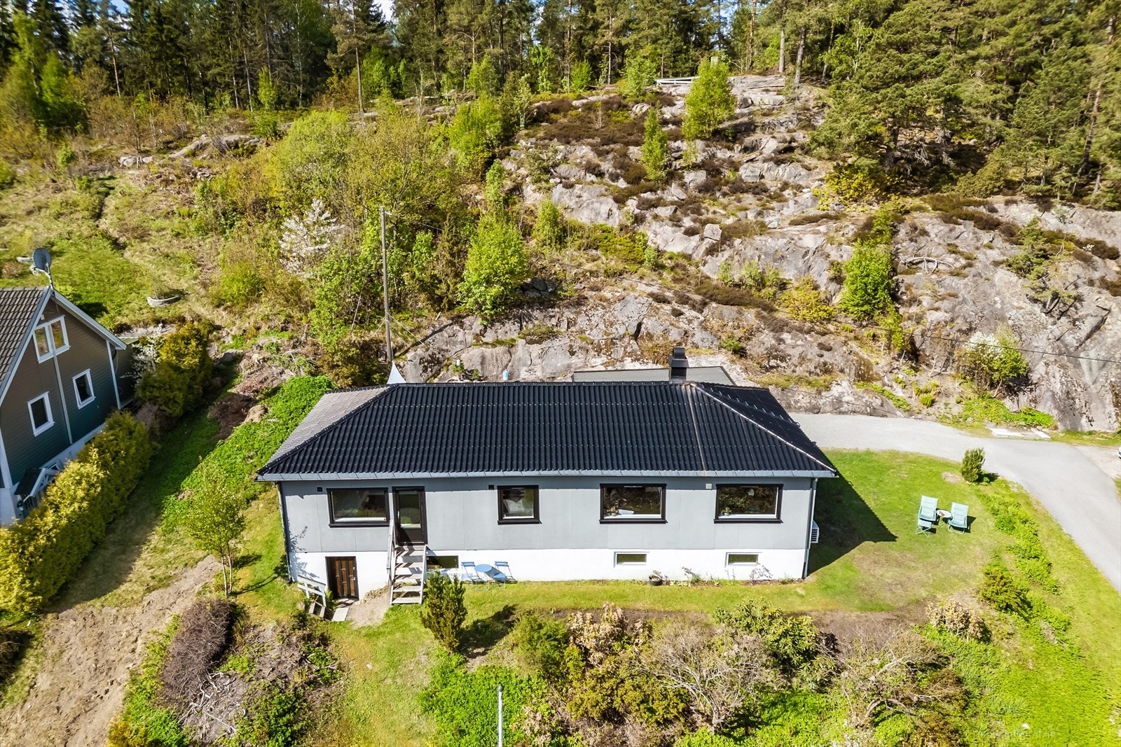 Eiendommen ligger høyt og fritt til på en tomt som grenser mot skogkledd terreng. Galleribilde