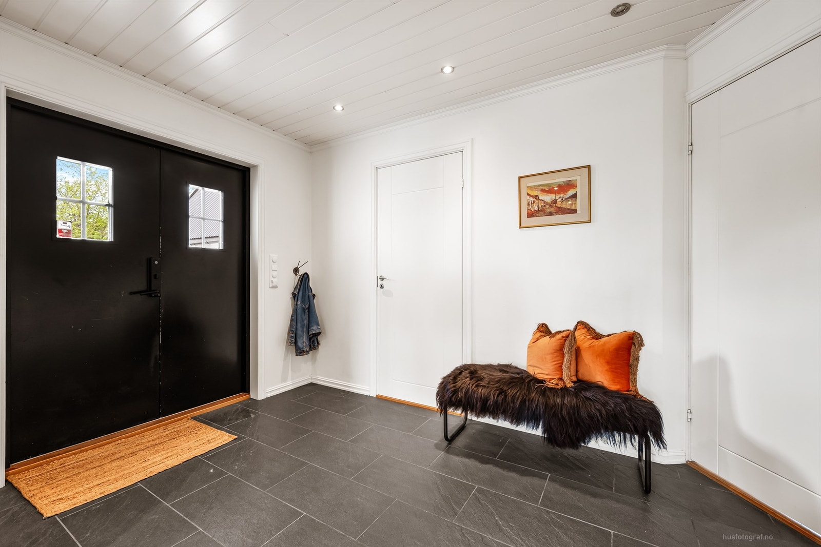 Entré med flislagt gulv, gulvvarme og innfelte downlights i himlingen. Herfra er det utgang til en platting ved inngangspartiet. Galleribilde