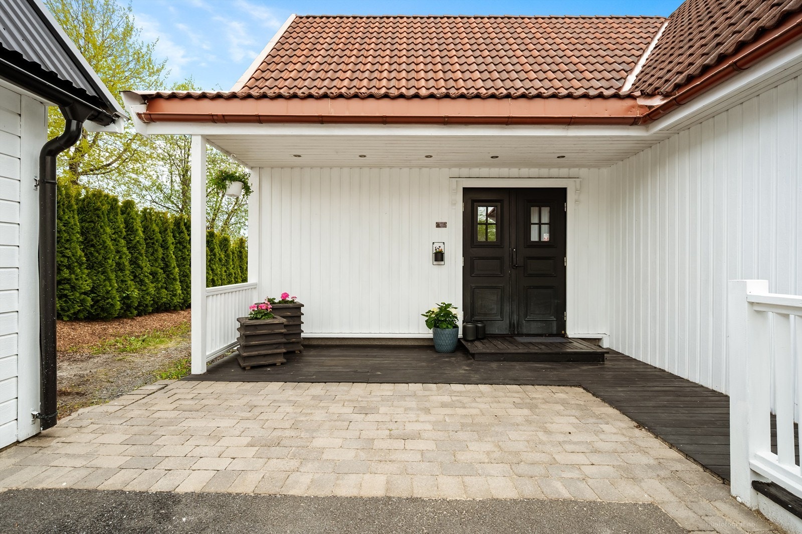 Overbygd inngangsparti med en platting på 10 kvm med utvendige downlights i tak. Galleribilde