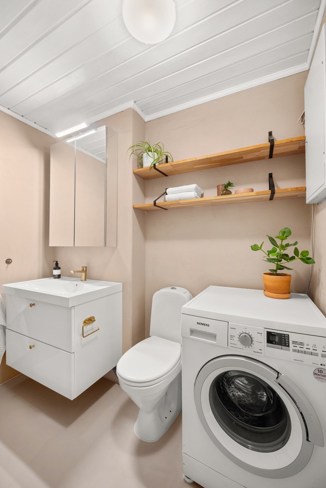 Badet er innredet med toalett og servant med oppbevaringsplass i innredning, samt speilskap med integrert belysning. Galleribilde