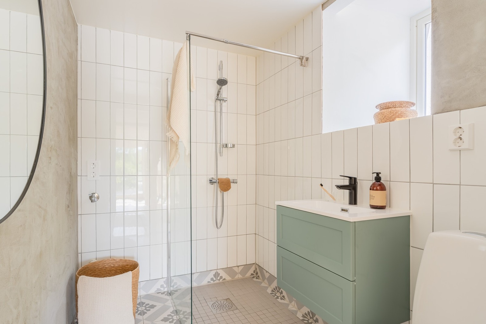 Fint helfliset bad innredet med vegghengt toalett, servant med innredning, dusj med glassvegger og opplegg for vaskemaskin. Galleribilde