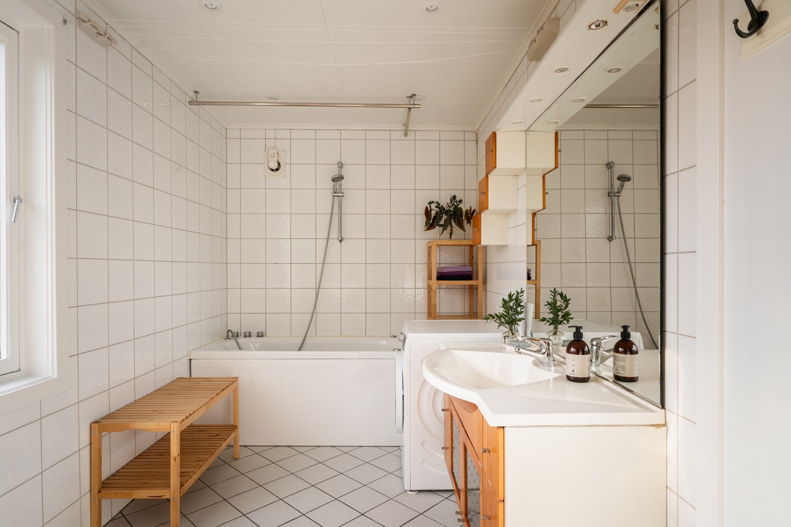 Flislagt bad innredet med badekar, servant og har opplegg for vaskemaskin. Galleribilde