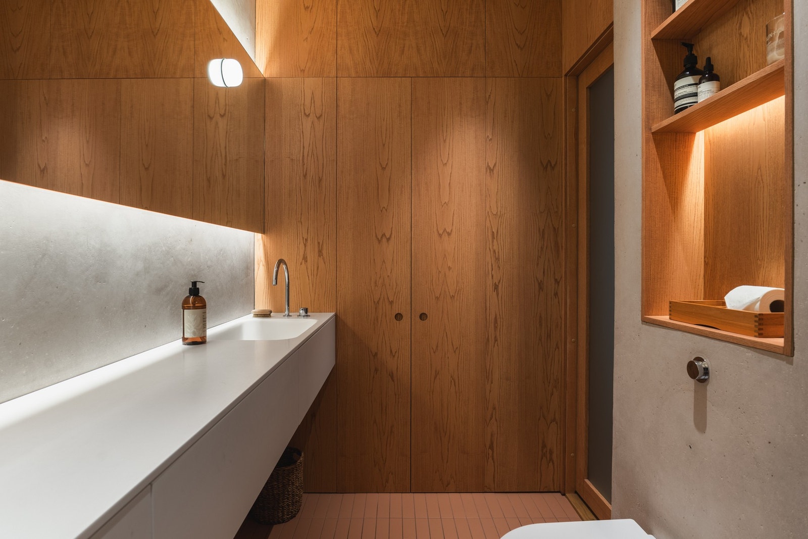 Badet har plassbygget skapinnredning med eikefinerte fronter og smarte nisjer for oppbevaring. Gjennomtenkt belysningsplan og indirekte lys skaper en behagelig atmosfære. Galleribilde