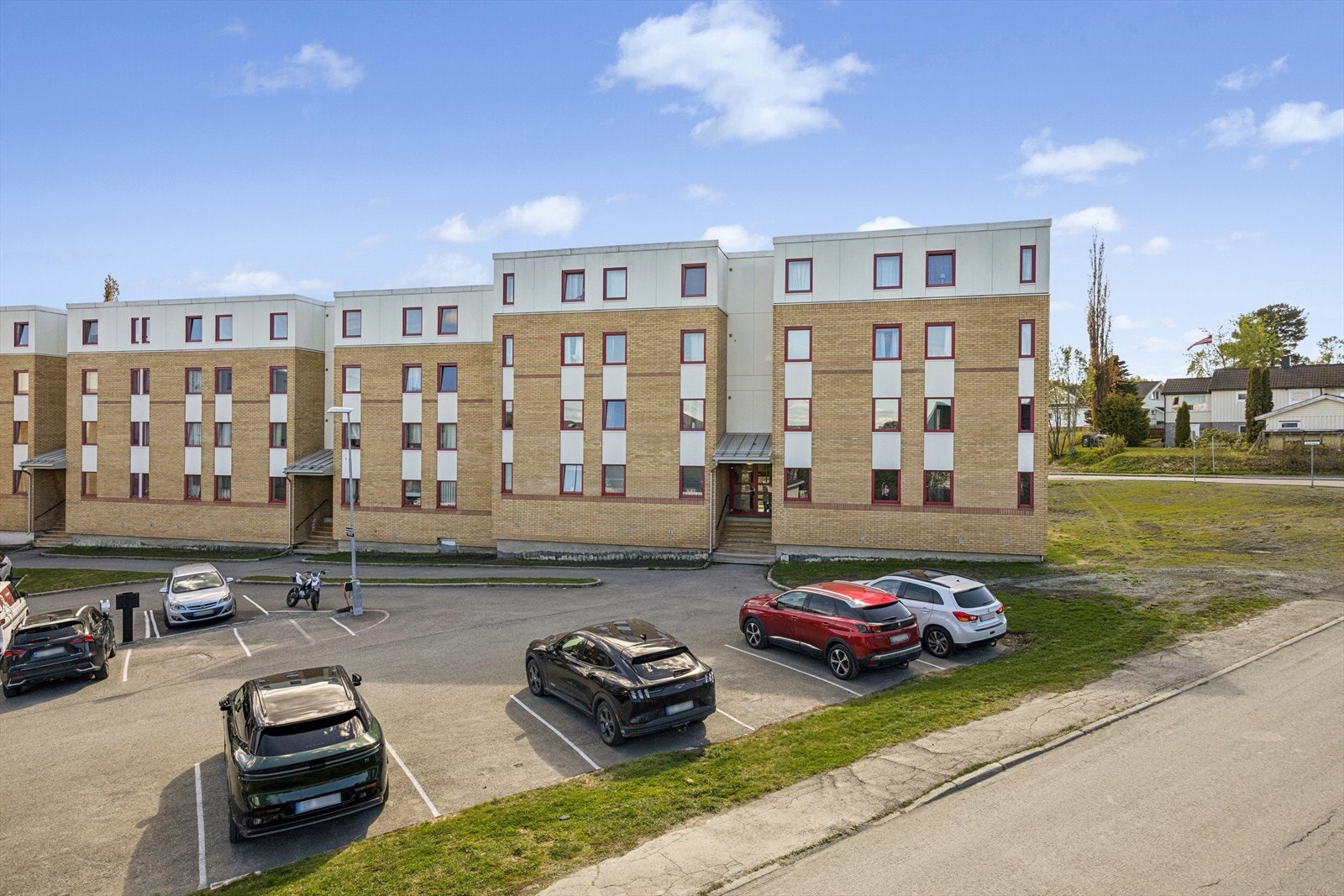 Felles parkeringsplass på byggets bakside, her er det også elbilladere. Galleribilde