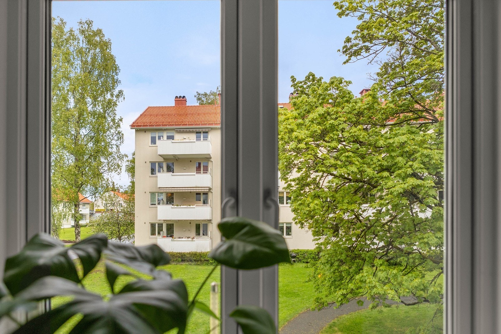 Fra leiligheten ser man ut mot de rolige og barnevennlige fellesområdene. Galleribilde