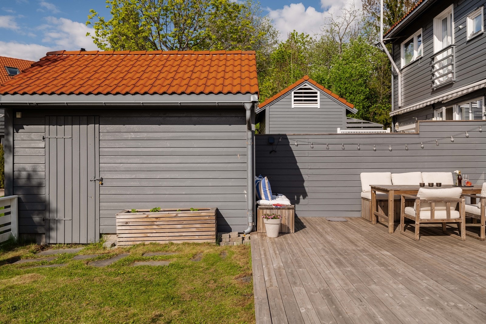 Uteplassen har en praktisk bod for oppbevaring av hageredskaper, sesongmøbler og leker for barna. Galleribilde