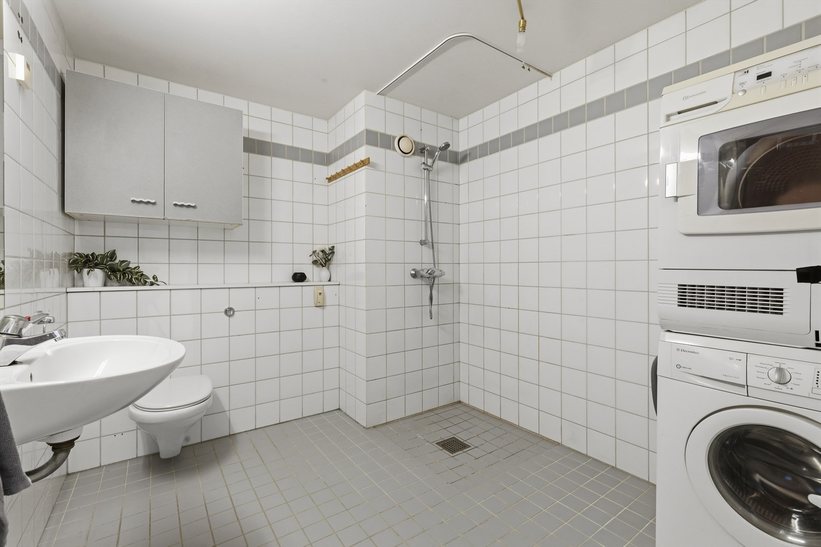 Romslig baderom med god plass og oppbevaringsmuligheter. Opplegg til vaskemaskin og tørketrommel. Galleribilde