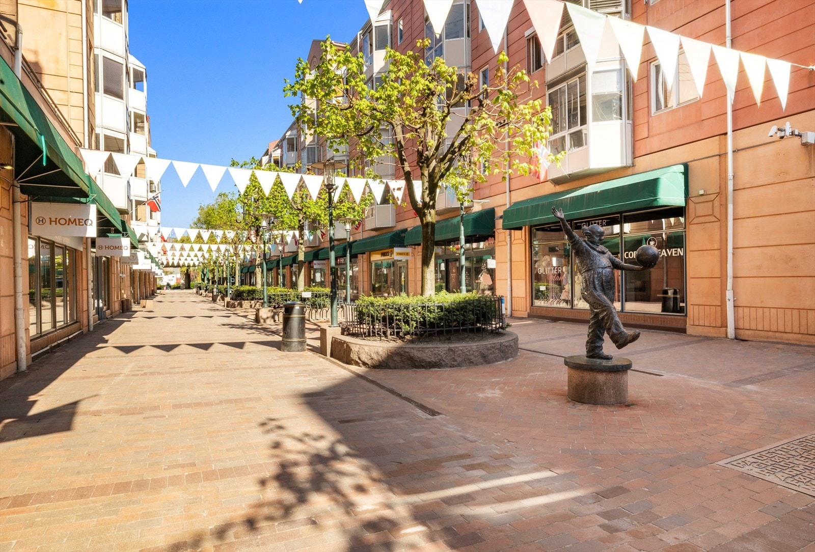Smalgangen er en koselig gate brosteinsbelagt og beplantet med diverse buskevekster og blomster. Galleribilde