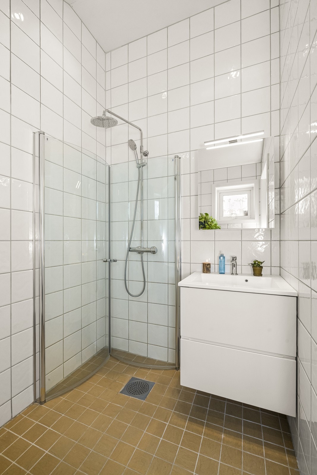 Badet i 1 etg. er flislagt og inneholder servant, vegghengt toalett og dusjhjørne. Galleribilde