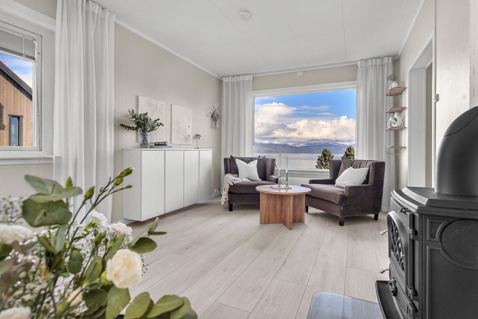 Store vindusflater gir rikelig med dagslys og rammer inn utsikten mot fjorden. Galleribilde