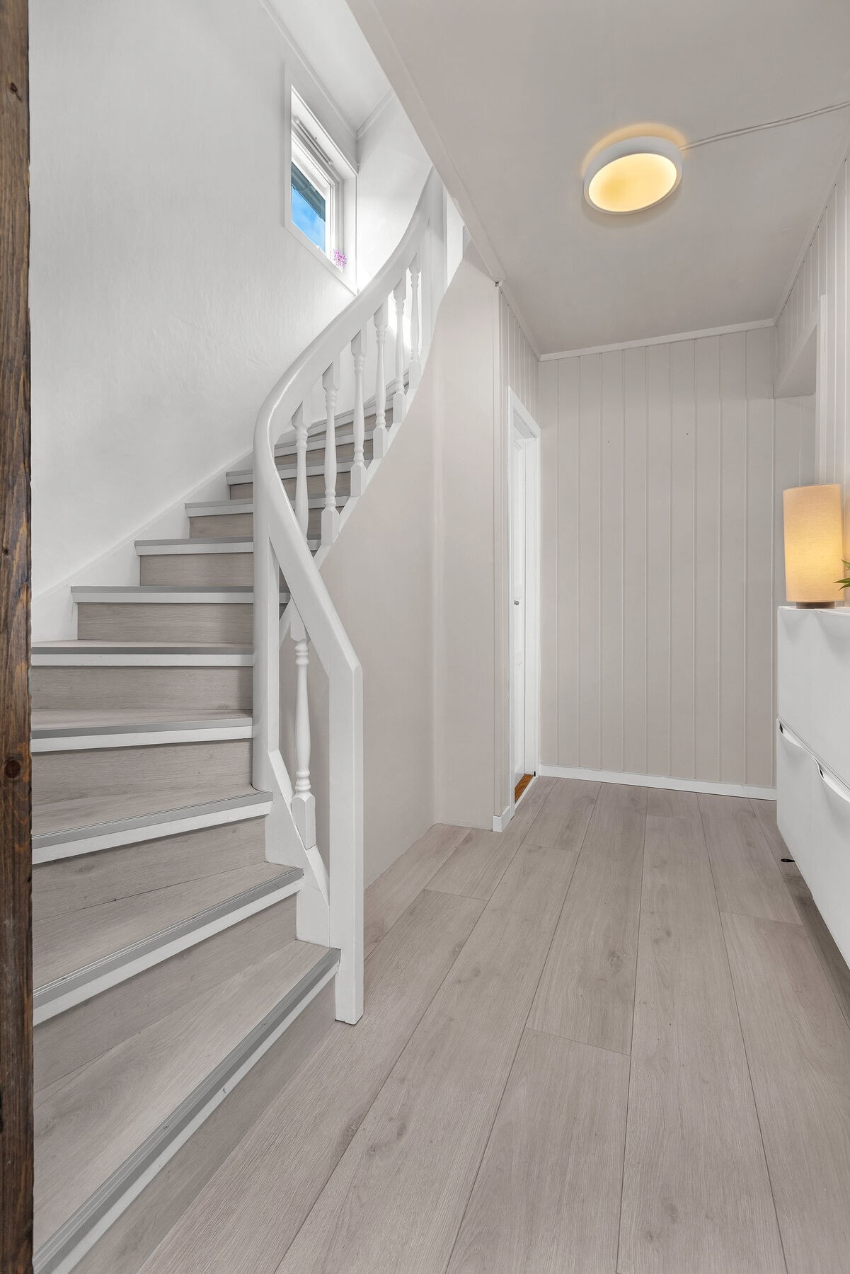 Den malte tretrappen med laminat i trinnene forbinder første etasje med loftet. Galleribilde