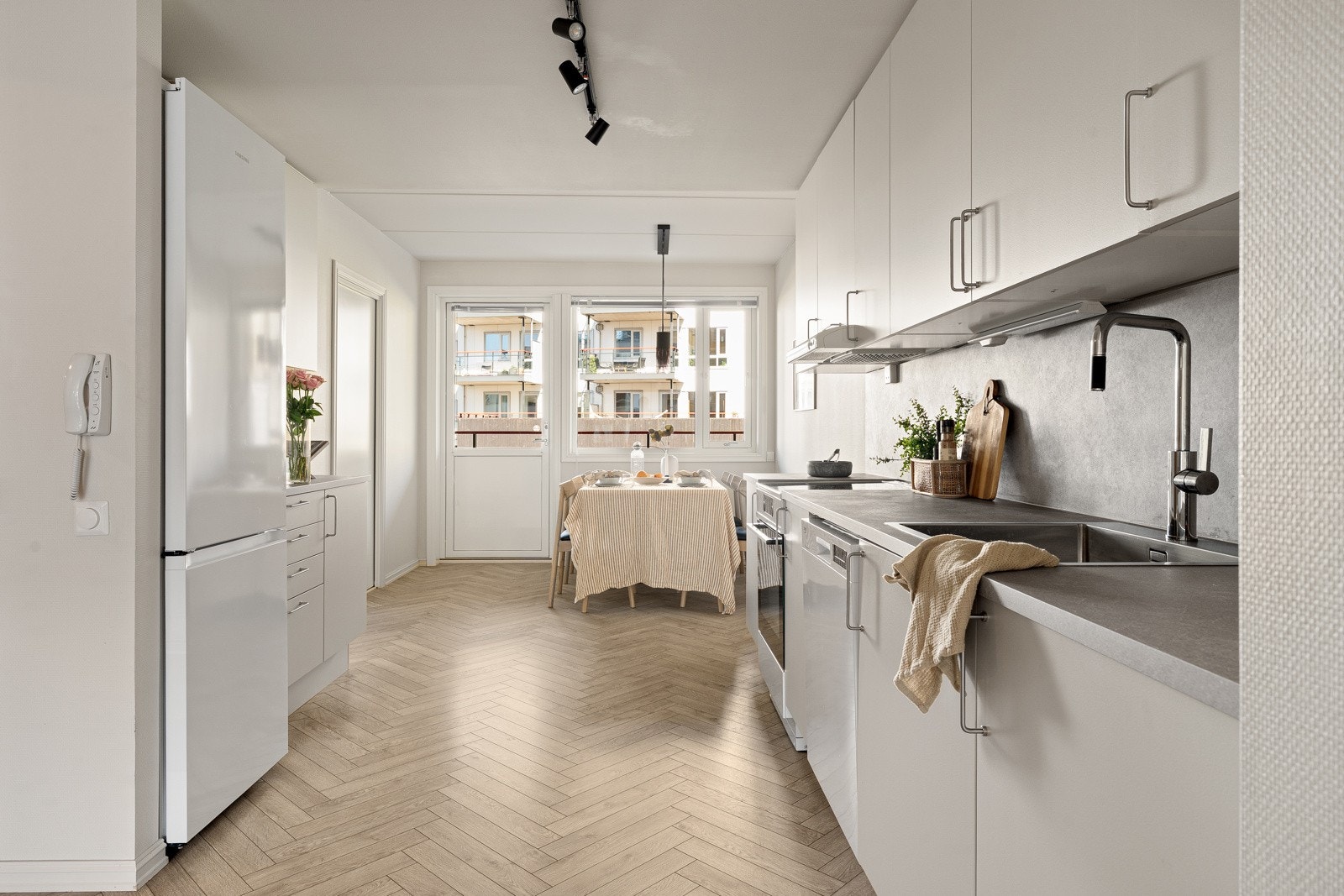 Den langstrakte kjøkkenløsningen gir god romfølelse og effektive arbeidsflater. Store vindusflater i endene av rommet slipper inn rikelig med dagslys. Galleribilde