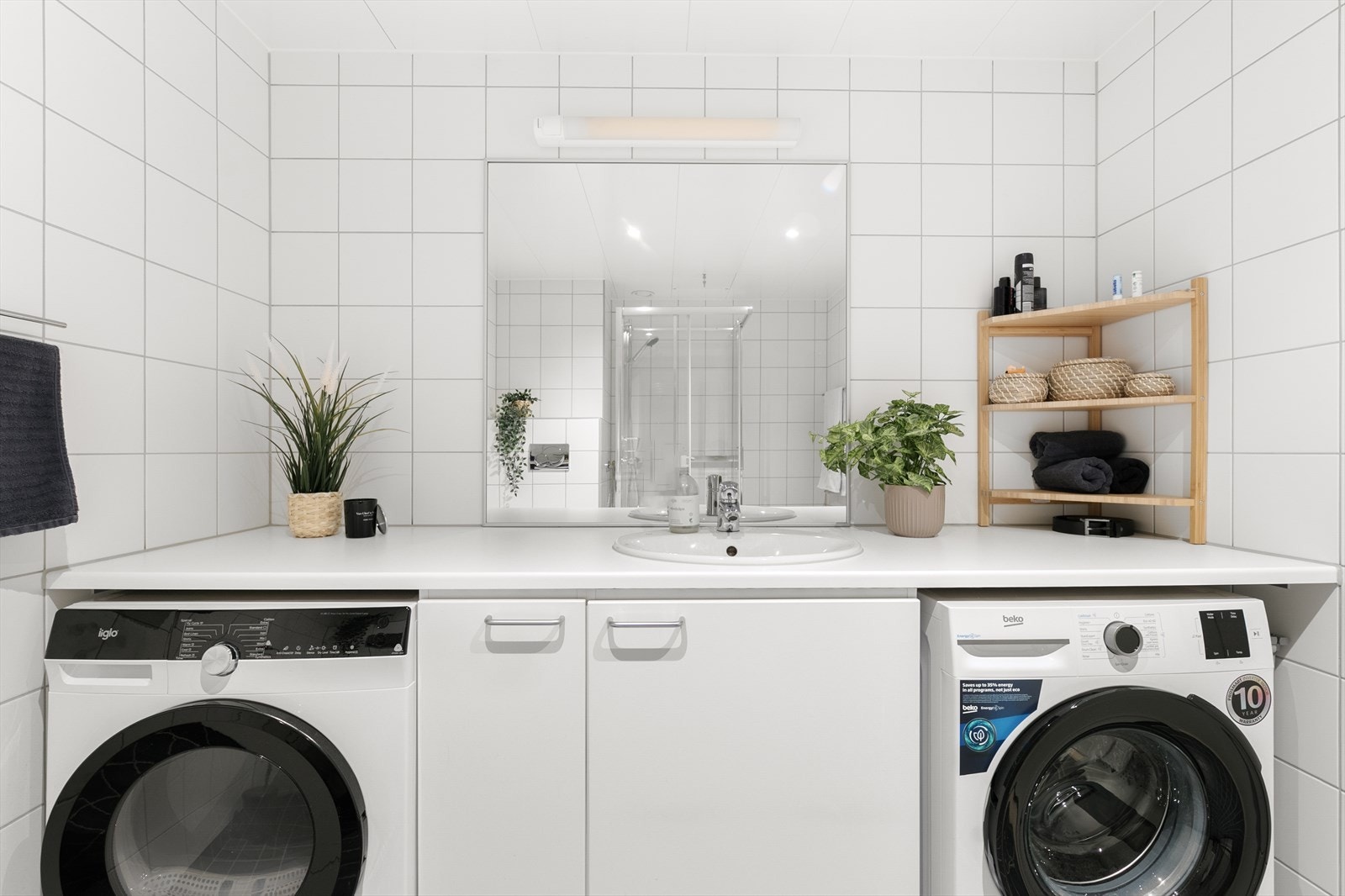 Badet inneholder nedfelt servant, veggmontert
toalett, dusjkabinett og opplegg for vaskemaskin og tørketrommel under benk. Galleribilde