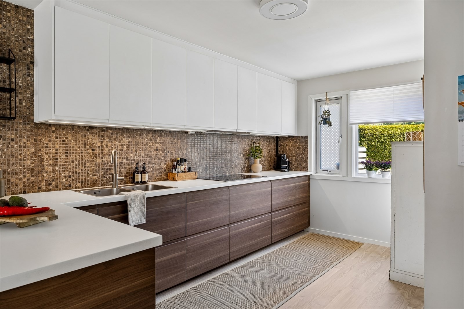 Kjøkkeninnredning fra IKEA (2018) med glatte fronter og laminatbenkeplate. Mosaikkfliser over benken ble lagt i 2020. Galleribilde