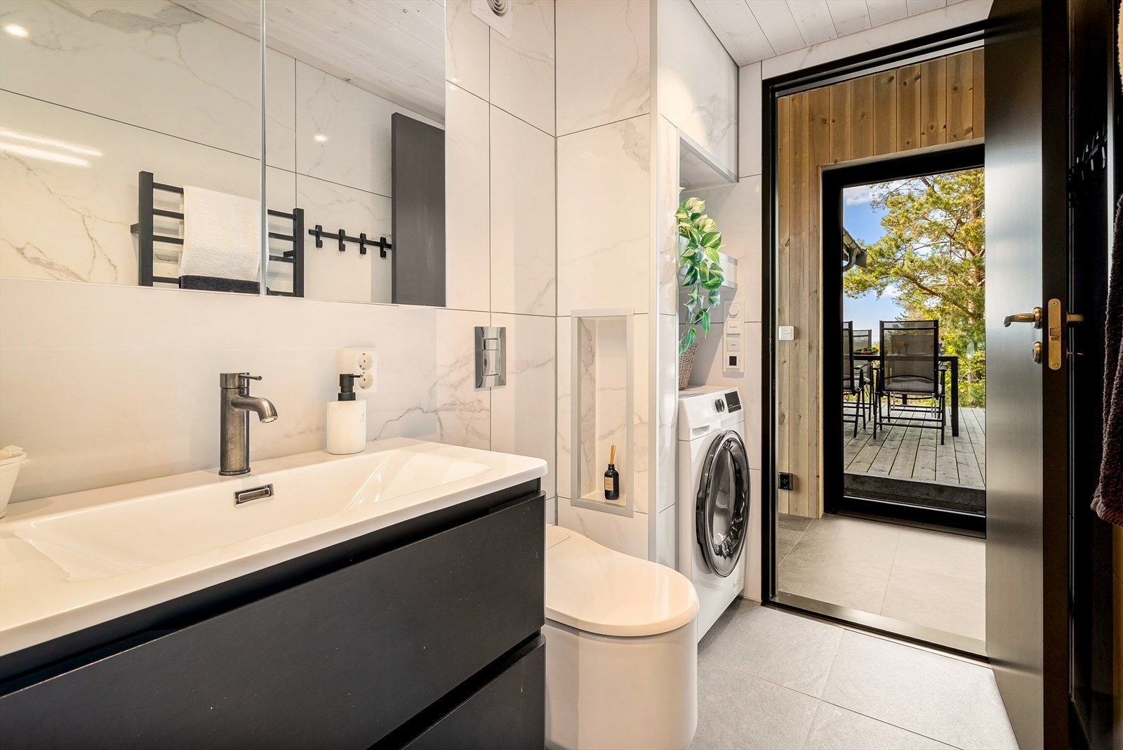 Badet har flislagt gulv med elektriske varmekabler og opplegg for vaskemaskin. Galleribilde