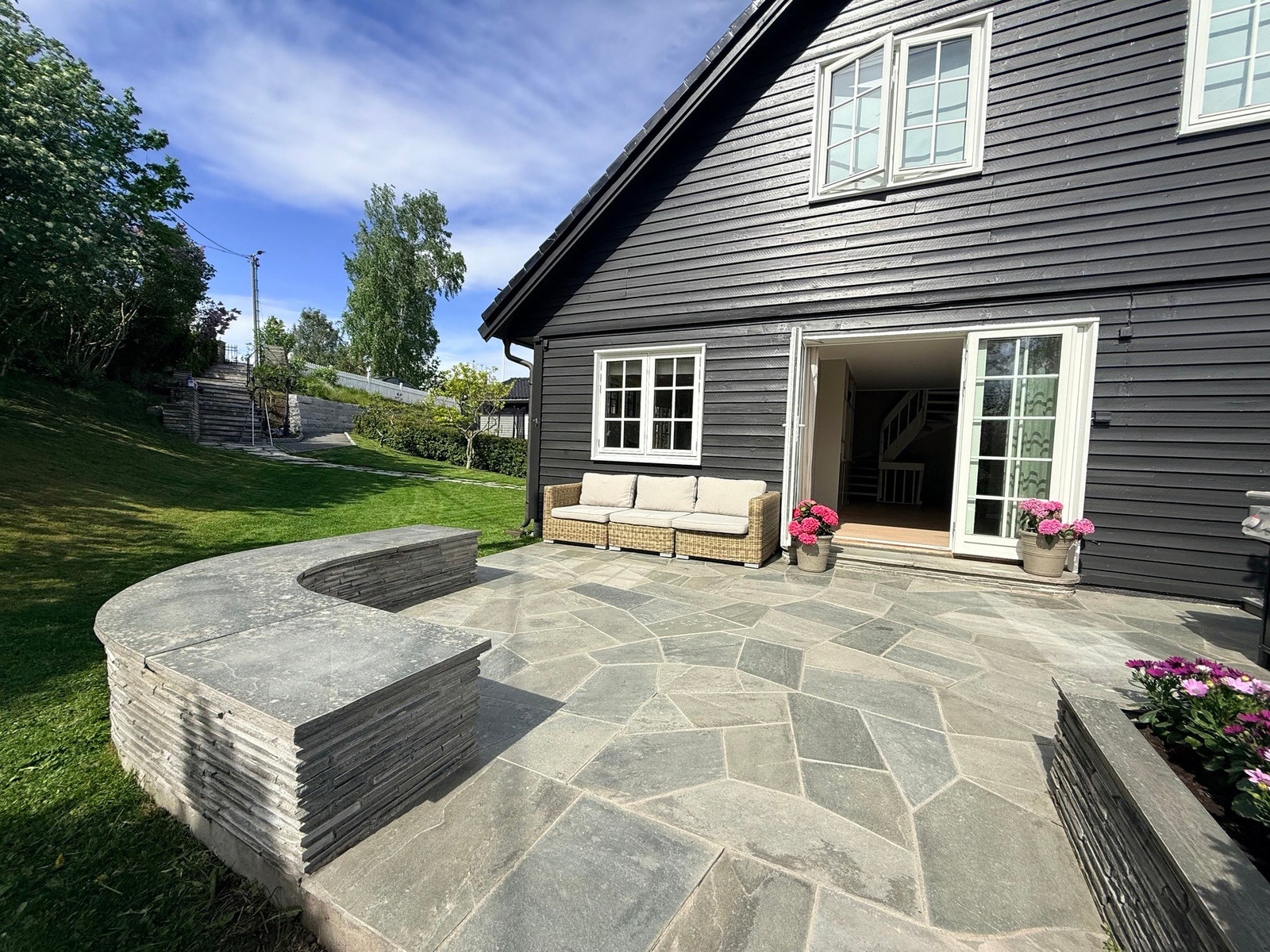 Den hellelagte uteplassen utenfor stuen gir god plass til lounge, grill og sosiale sommermåltider. Galleribilde