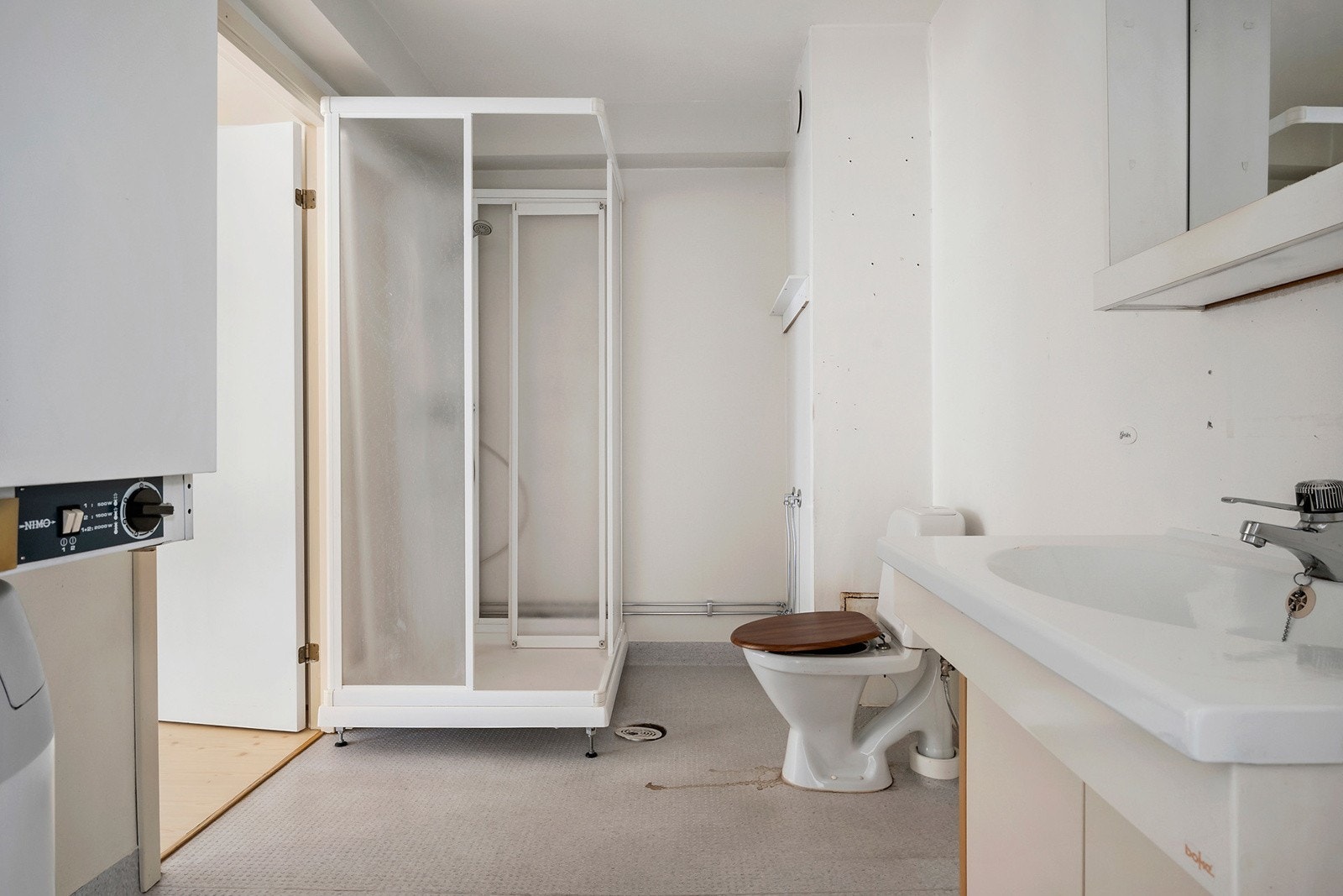 Badet er innredet med dusjkabinett, toalett og servant med underskap. Galleribilde