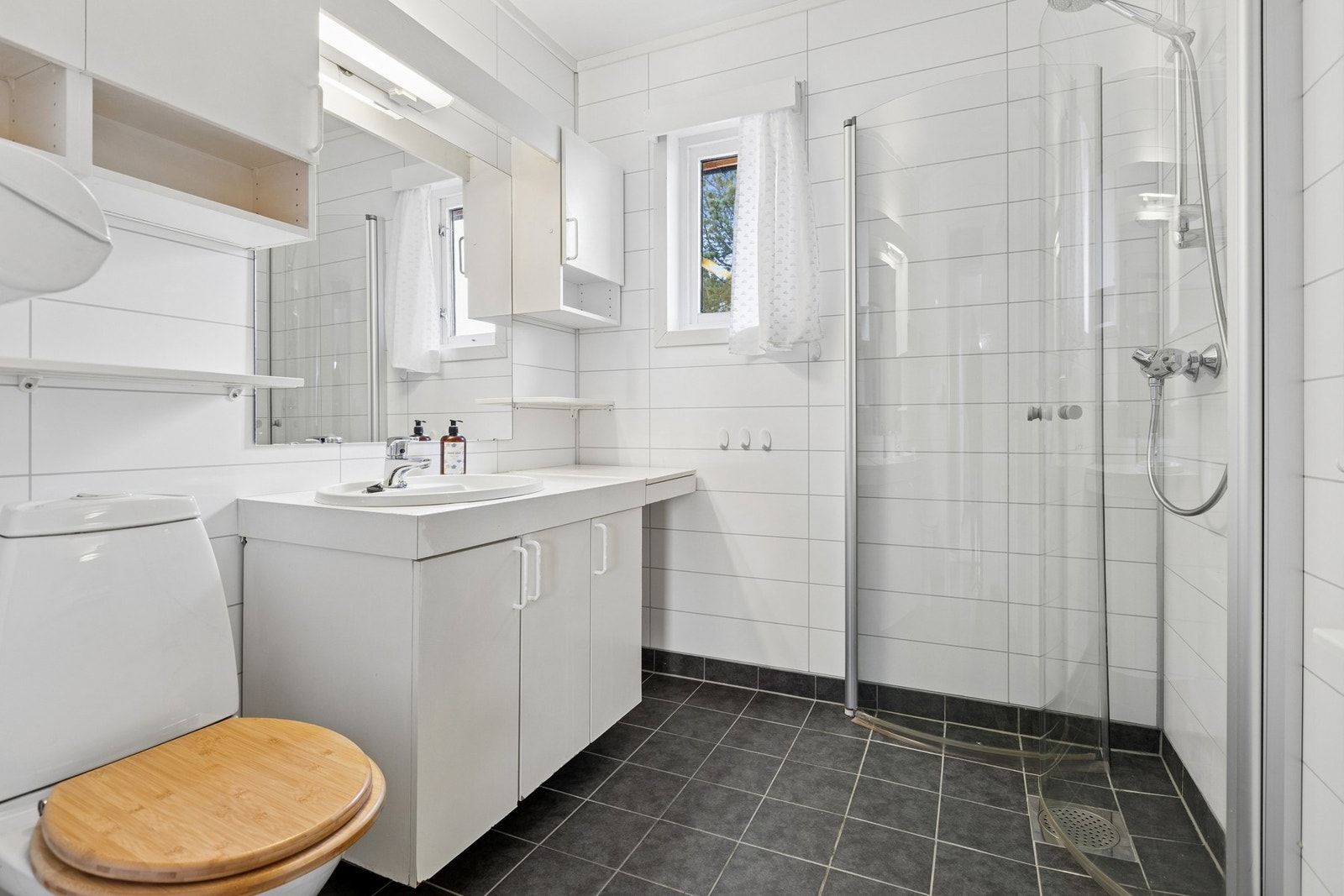 Baderom i hovedetasjen har fliser på gulv og plater på vegger. Foto: EFKT Galleribilde