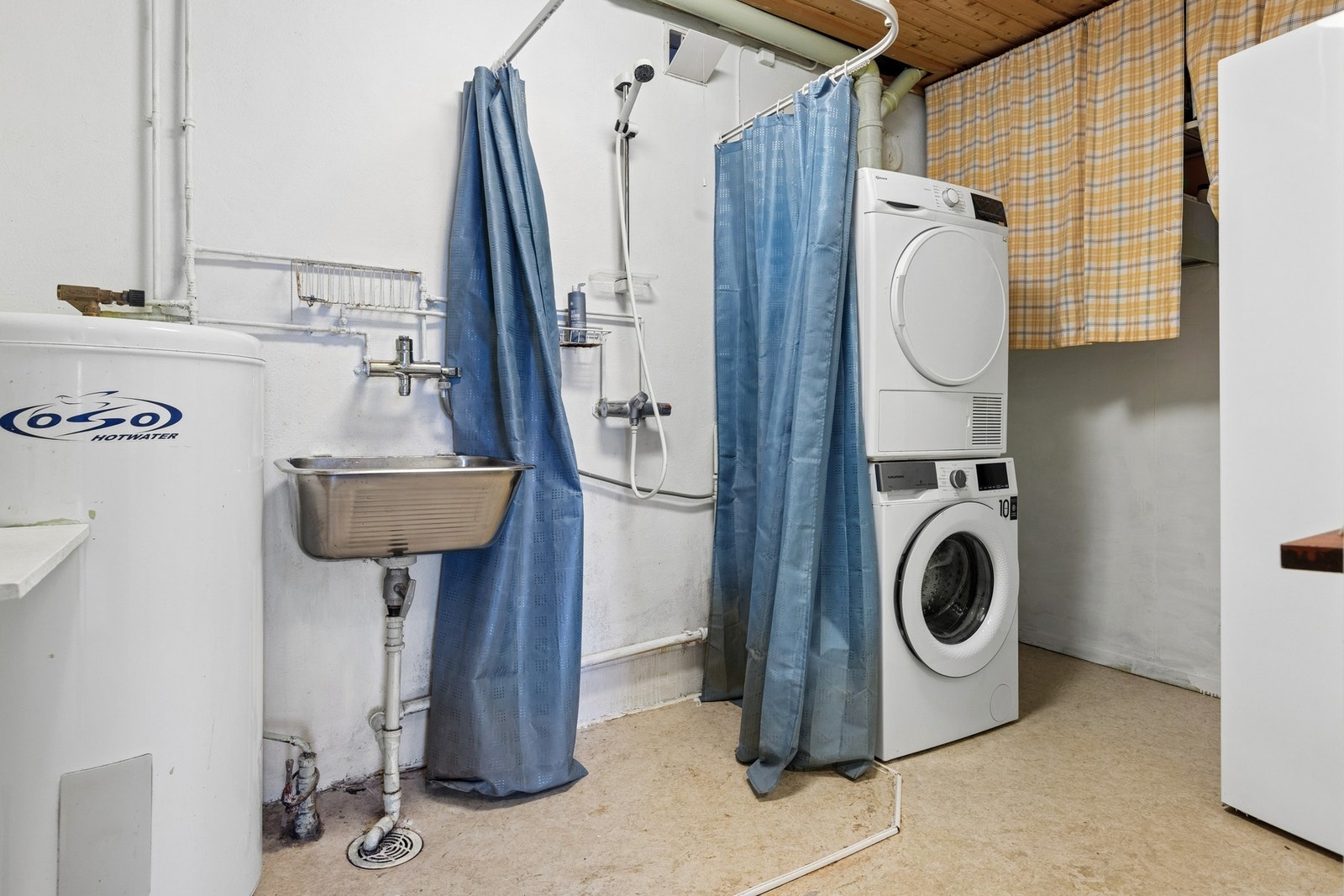 Romslig vaskerom med dusjløsning og opplegg for vaskemaskin. Foto: EFKT Galleribilde