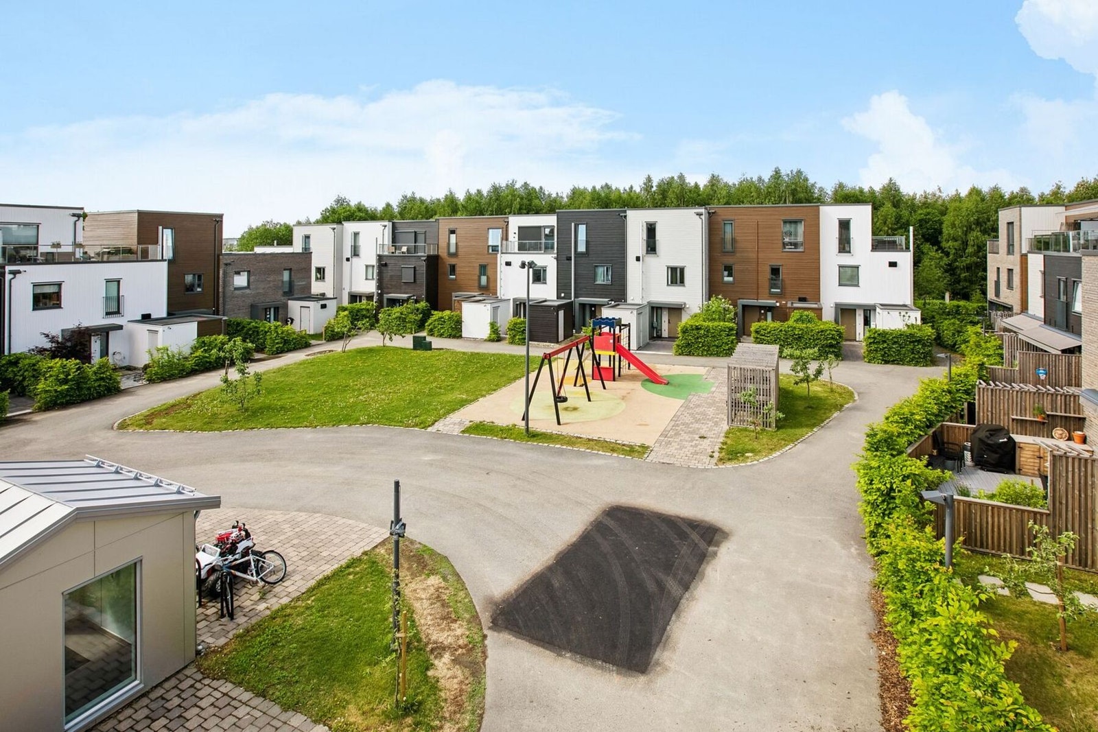 Fellesarealer opparbeidet med asfalterte internveier, plenareal, prydbusker og diverse beplantninger. Galleribilde