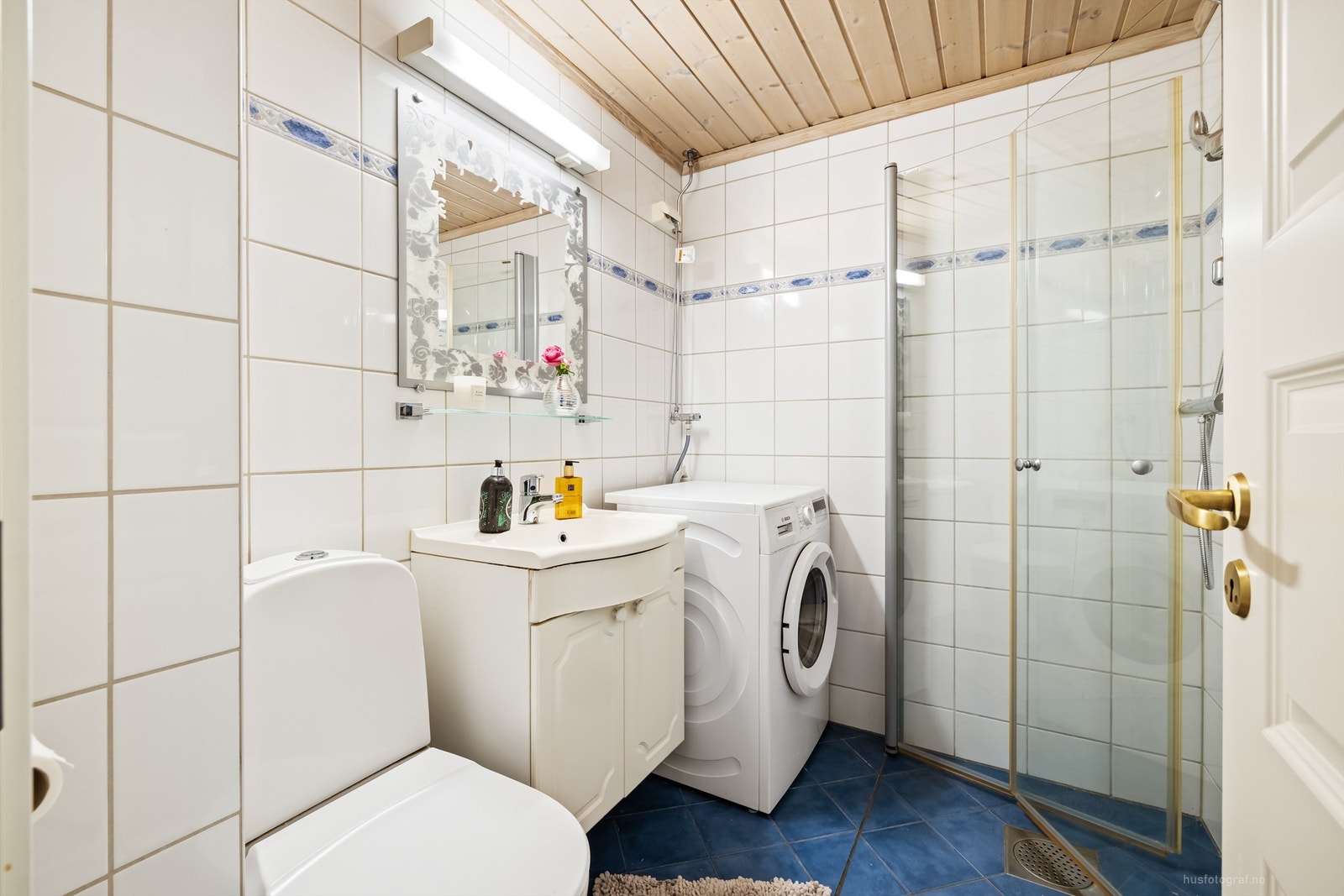 Badet har dusjhjørne med foldedører av glass og gulvvarme. Galleribilde