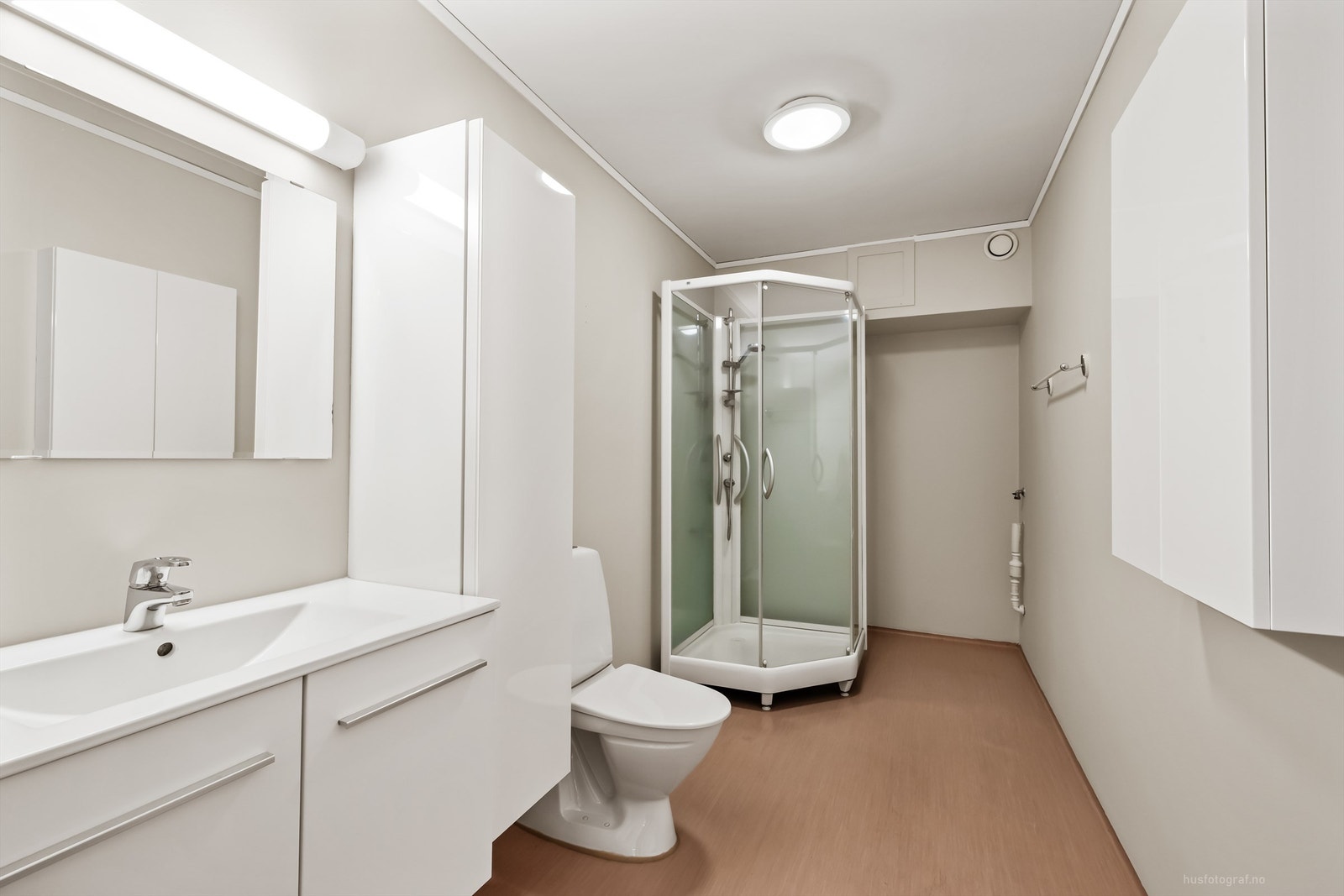 Videre er badet utstyrt med gulvstående toalett og dusjkabinett. Galleribilde