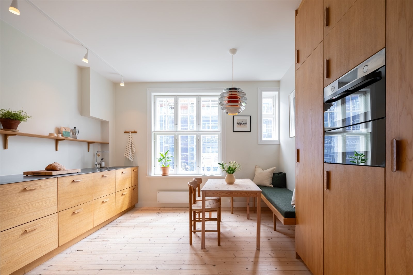 Kjøkkenet har en gjennomgående helhet med fronter, sittebenk, hylle og knaggrekke i eik. Den plassbygde sittebenken har sitteputer i ull og følger med leiligheten. Galleribilde