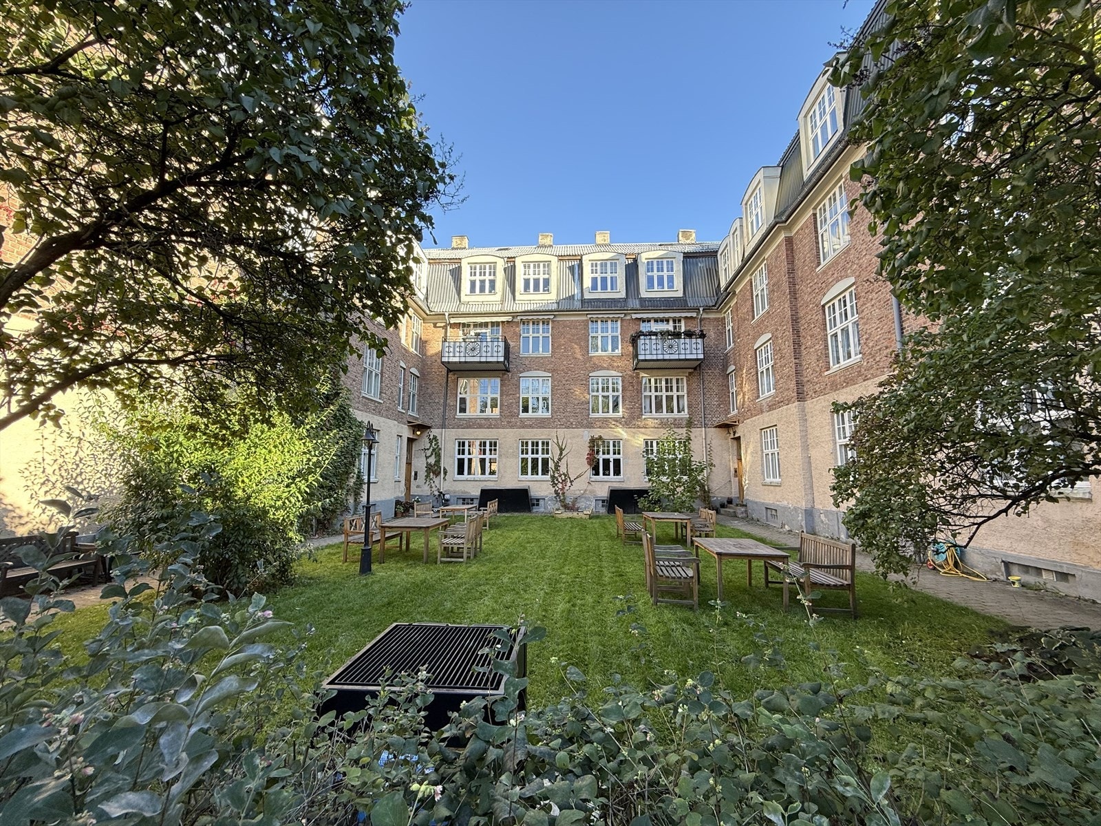 Vakker forhage med sittegrupper og felles grill. Galleribilde