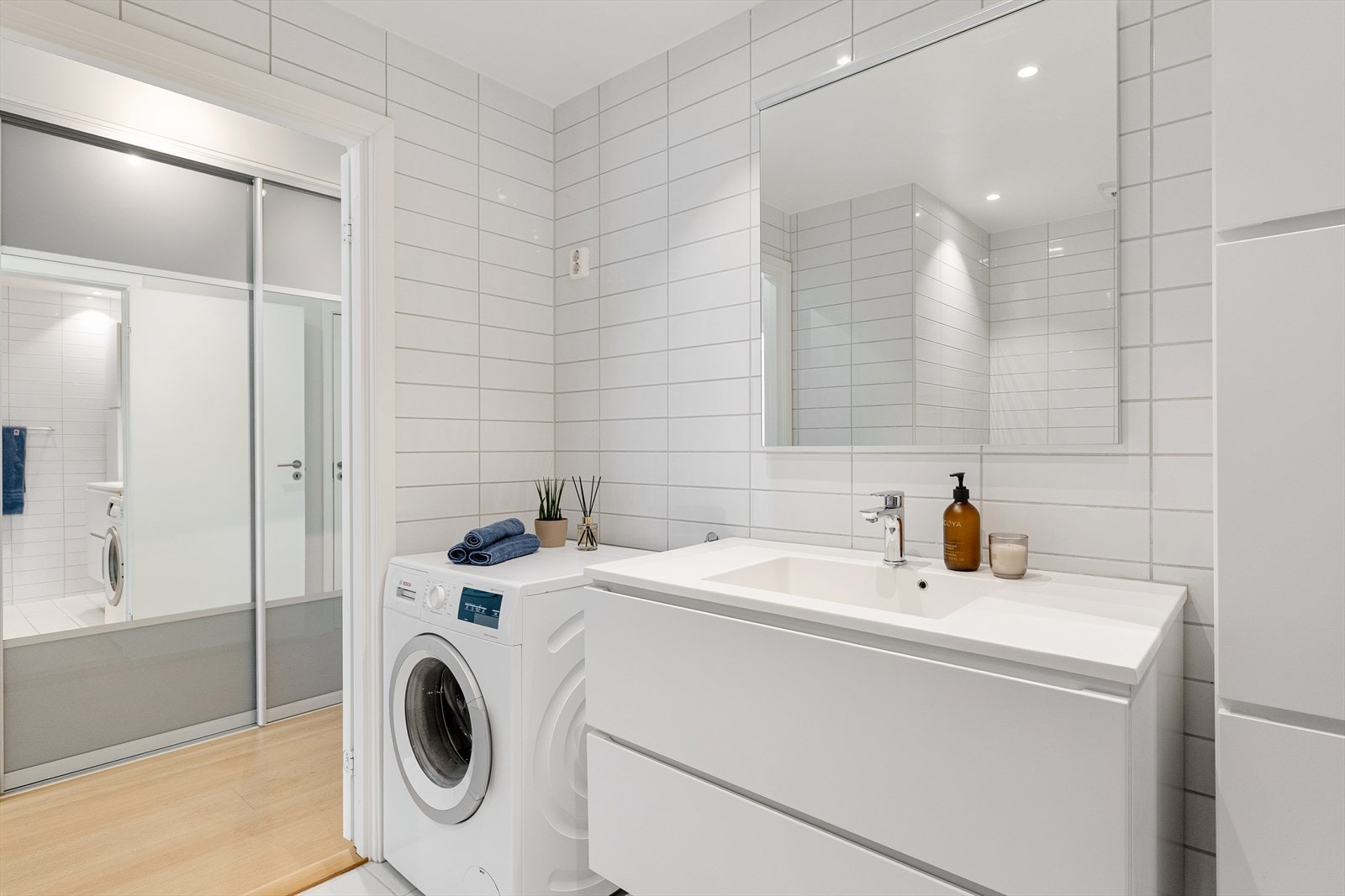 Badet er innredet med servantskap med nedfelt servant, speil med belysning, veggskap og vegghengt toalett. Galleribilde