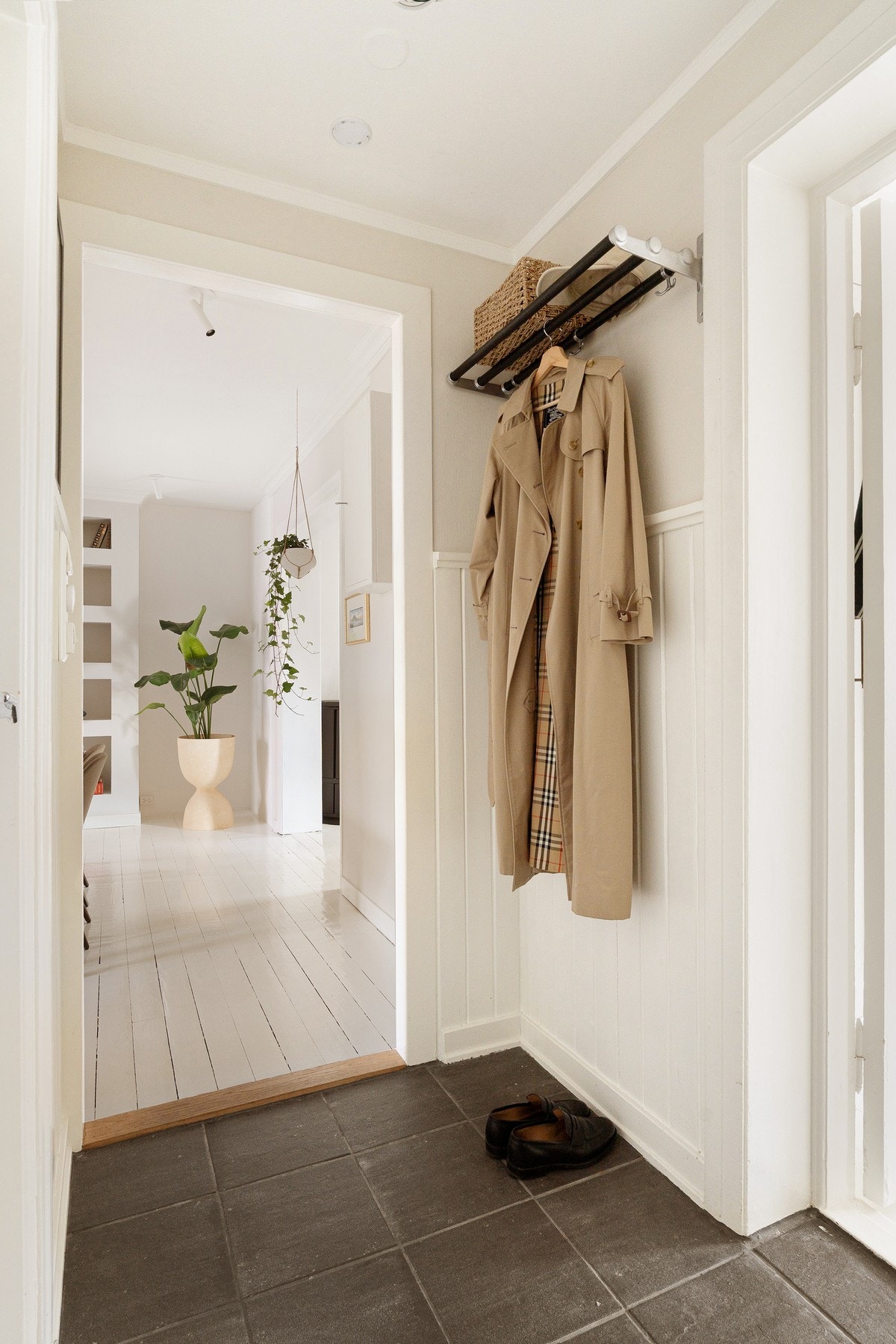 Velkommen inn! Entréen gir et ryddig og godt førsteinntrykk av boligen, med flislagt gulv og plass til å henge fra seg yttertøy og sko på en praktisk måte. Galleribilde