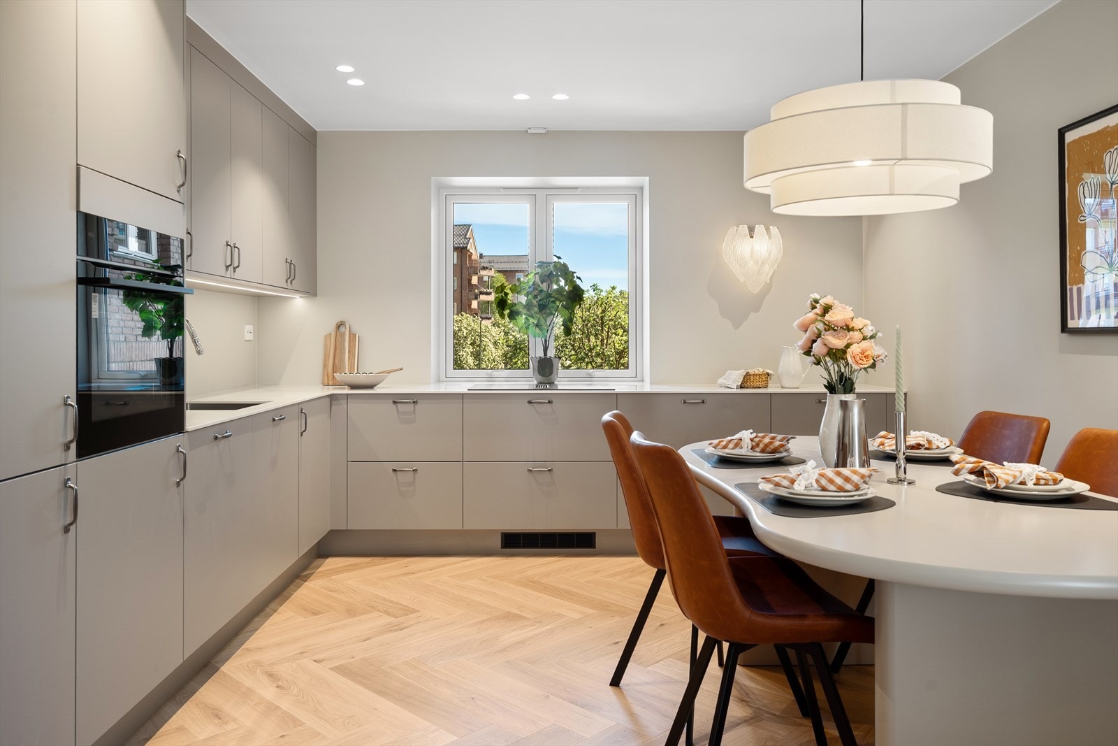 Stilrent og funksjonelt HTH-kjøkken med moderne kjøkkeninnredning med glatte fronter, og kompositt/porselen benkeplate med nedfelt vaskekum. Galleribilde